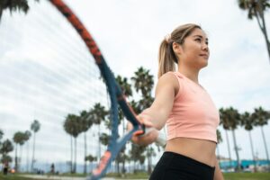 Active woman playing tennis in park with palm trees surrounding